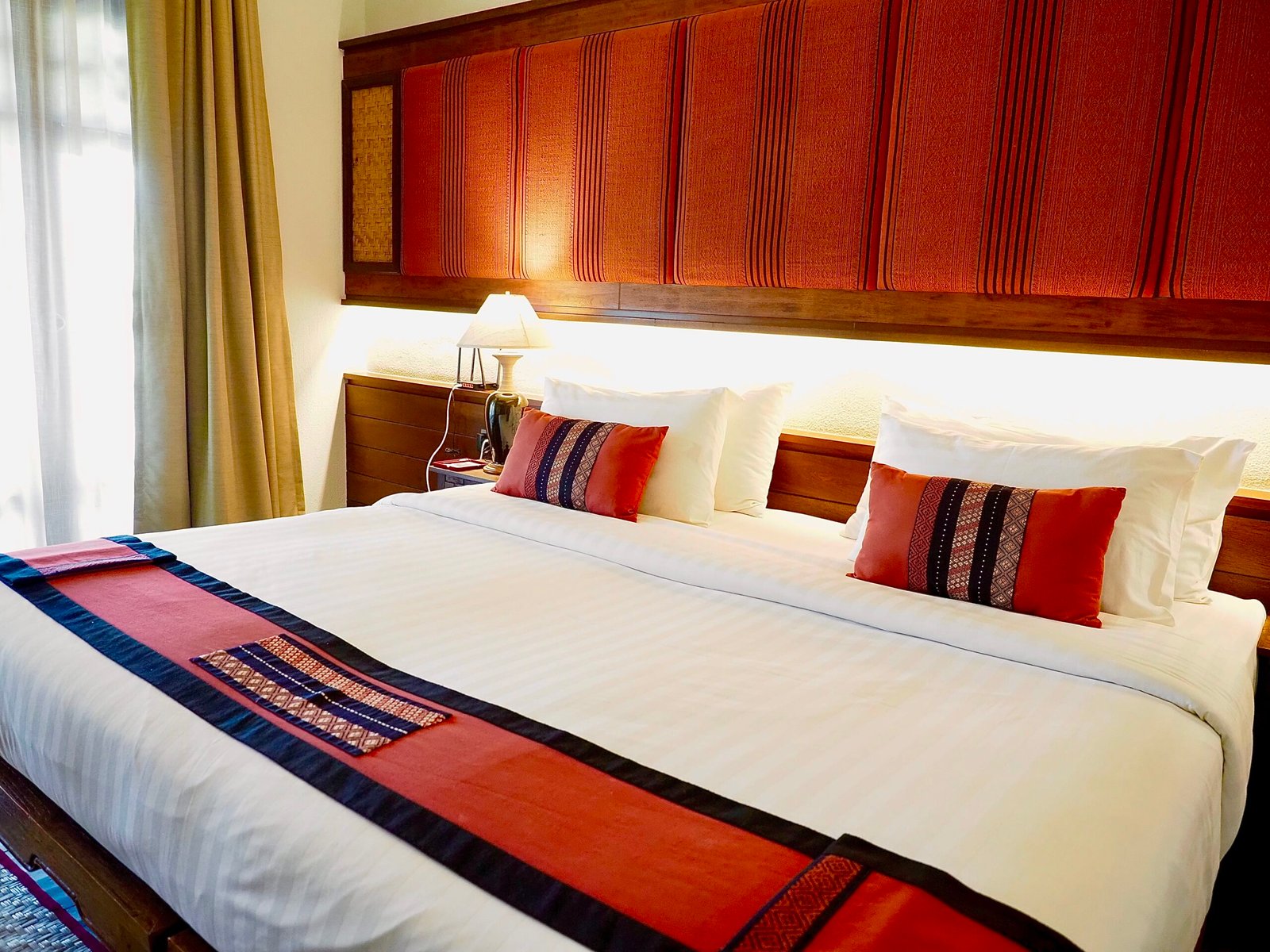 hotel bed features a plush mattress, crisp white linens, soft pillows, and a cozy duvet, creating a comfortable and inviting space for restful sleep